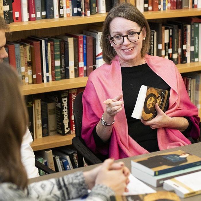 Smiling faculty member leads small class discussion